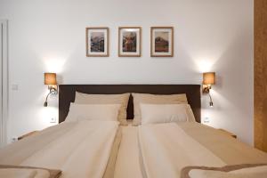 een slaapkamer met een groot bed met drie foto's aan de muur bij die Tauplitz Lodges - Bergblick Lodge B1 by AA Holiday Homes in Tauplitz
