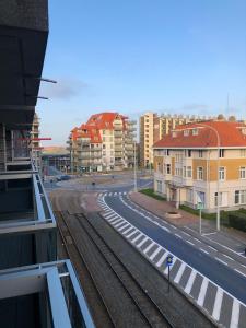 a view of a street with buildings and train tracks at "Cosy Dune", trendy en zuid gelegen ruim appartement op 100m van strand en winkelstraat in Nieuwpoort