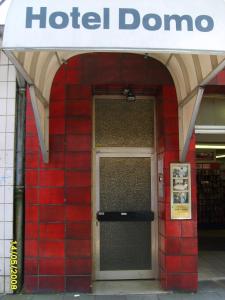 a red brick building with a hotel door at Domo Hotel Mondial in Düsseldorf