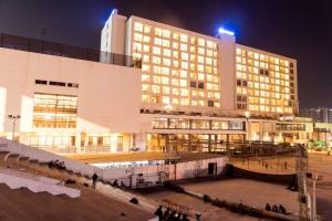 a large building with people standing outside of it at night at Wyndham Ahmedabad Shela in Ahmedabad
