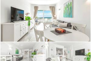 a white living room with a table and a tv at Apartment in complex Altamira with direct ocean view in Adeje