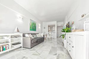uma sala de estar branca com um sofá e uma mesa em Apartment in complex Altamira with direct ocean view em Adeje