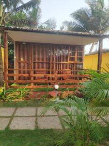 a house with a porch with chairs in front of it at Sea Front Beach Huts in Patnem