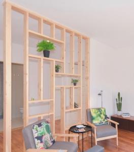 a living room with a book shelf with potted plants at Peixinho Avenue Apartment in Aveiro