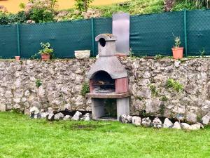 pared de piedra con horno al aire libre en el césped en Casa frente a los Bufones de Pria en Llames de Pría