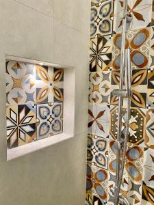 Łazienka z prysznicem i mozaikami na ścianie w obiekcie Dadaumpa suite w mieście Lecce