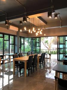 a dining room with tables and chairs and windows at ABIZZ Hotel KwanPhayao in Phayao