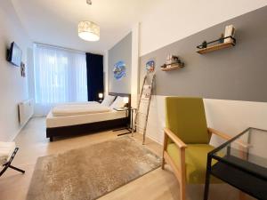 a bedroom with a bed and a chair and a table at Kangarooms - Schlachte Weserpromenade in Bremen