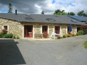 ein Steinhaus mit einem weißen Stuhl davor in der Unterkunft Gîte - La Rigaudière in Le Theil-de-Bretagne