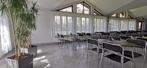 a dining room with tables and chairs and windows at Dom Wczasowy Irys in Węgierska Górka