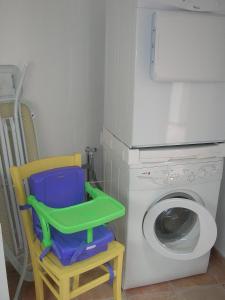 lavadero con lavadora y silla en Gîte - La Rigaudière, en Le Theil-de-Bretagne