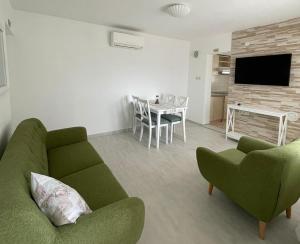 a living room with a green couch and a table at Kuća za odmor Alf in Rab