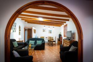 un arco en una sala de estar con sofá y mesa en Villa NARE - Casa típica majorera, en Villaverde