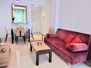 sala de estar con sofá rojo y mesa en ACV - Aguamarina-2ª linea, planta 8, norte, en Oropesa del Mar