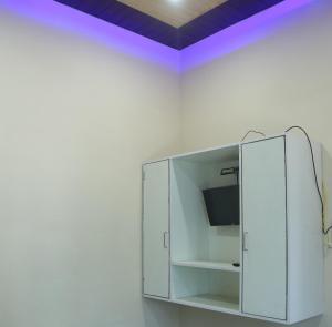 a white cabinet with a tv on a wall at Hotel Siddharth in Tanakpur