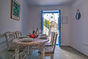 a dining room with a table with wine glasses at Casa Beaumont - awesome Andalusian townhouse in Cómpeta