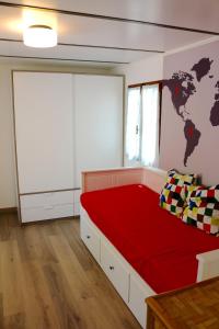 a bedroom with a red bed with a world map on the wall at Sardinia MongaHouse in Tertenìa
