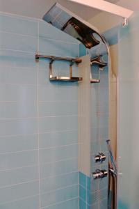 Łazienka z prysznicem wyłożona jest niebieskimi kafelkami. w obiekcie Sardinia MongaHouse w mieście Tertenìa