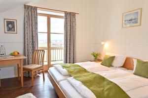 Schlafzimmer mit einem Bett, einem Schreibtisch und einem Fenster in der Unterkunft Gasthaus - Hotel Alt Fürstätt in Rosenheim