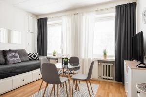 een woonkamer met een bank en een tafel en stoelen bij Apartments Borg in Pori