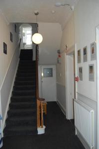 a hallway with a staircase with a guitar in it at The George B&B in Weymouth