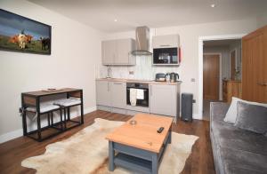 a kitchen and living room with a couch and a table at Scorr House Apartment in Portree
