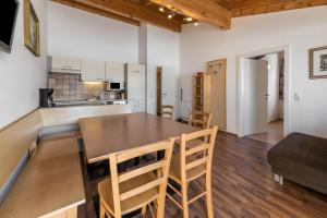a kitchen and dining room with a wooden table and chairs at Chalet Central - Top Cc8 in Königsleiten