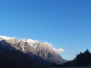Una cadena montañosa cubierta de nieve con un cielo azul en Apartament GreenStar, en Sinaia