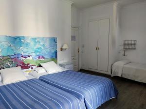 um quarto com duas camas e um quadro na parede em Ronda Hotel Polo em Ronda