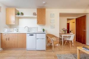 a kitchen with a sink and a table with chairs at 2 Bedroom Apartment in a Quiet Neighbourhood in St. Andrews