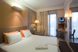 a hotel room with two beds and a television at Central Hotel in Athens