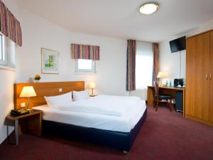 a hotel room with a bed and a desk at ACHAT Hotel Darmstadt Griesheim in Darmstadt