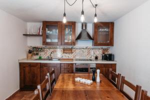 a kitchen with wooden cabinets and a wooden table with chairs at Villa Filipa in Brkač