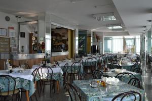 una sala da pranzo con tavoli e sedie di Hotel Elvira a Rimini