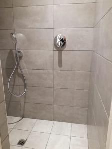 een douche met een douchekop in de badkamer bij 't Vossenerf in De Haan