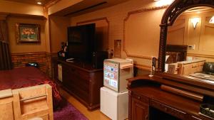 a room with a television and a room with a bed at Hotel Zips (Adult Only) in Kawaguchi