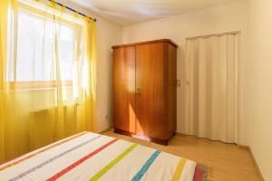 una camera da letto con un letto e un armadio in legno di Ferienwohnung Alina a Singen