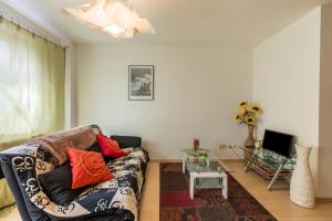 un soggiorno con un divano e un tavolo di vetro di Ferienwohnung Alina a Singen