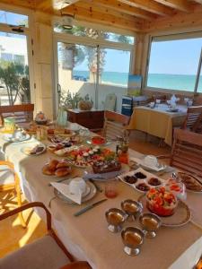 una mesa con comida y vistas al océano en Casa Mia, en Ouled Kacem