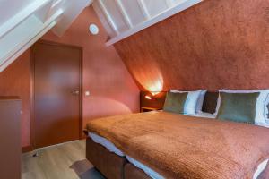 a bedroom with a large bed with a red wall at DRL08 Luxury apartment with sauna in centre in Domburg