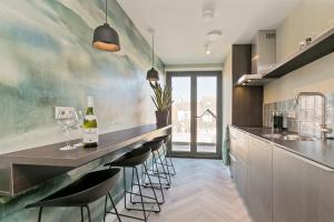 cocina con barra y botella de vino en DRL08 Luxury apartment with sauna in centre en Domburg