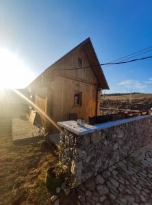 a barn with a stone wall in front of it at Brvnara Krin 2 in Nova Varoš