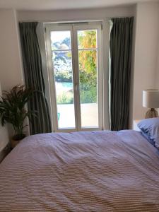 a bedroom with a bed and a large window at Close Quarters in Newton Ferrers