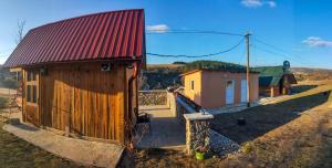 un pequeño edificio de madera con techo rojo en Brvnara Krin 2, en Nova Varoš