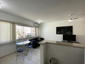 a living room with a table and a couch at Lindo apartamento mobiliado in Capão da Canoa
