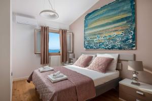 a bedroom with a bed with a painting on the wall at Villa Tela with Pool in Zaboric +57 photos