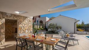a wooden table and chairs on a patio at Villa Tela with Pool in Zaboric