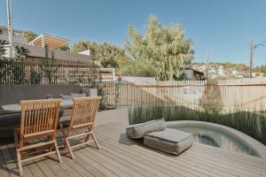 a patio with two chairs and a bench and a pool at Elsa Modern Apartments in Paleros