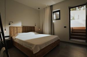 a bedroom with a large bed and a window at Elsa Modern Apartments in Paleros