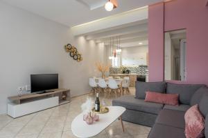 uma sala de estar com um sofá e uma televisão em JT Apartments em Kissamos